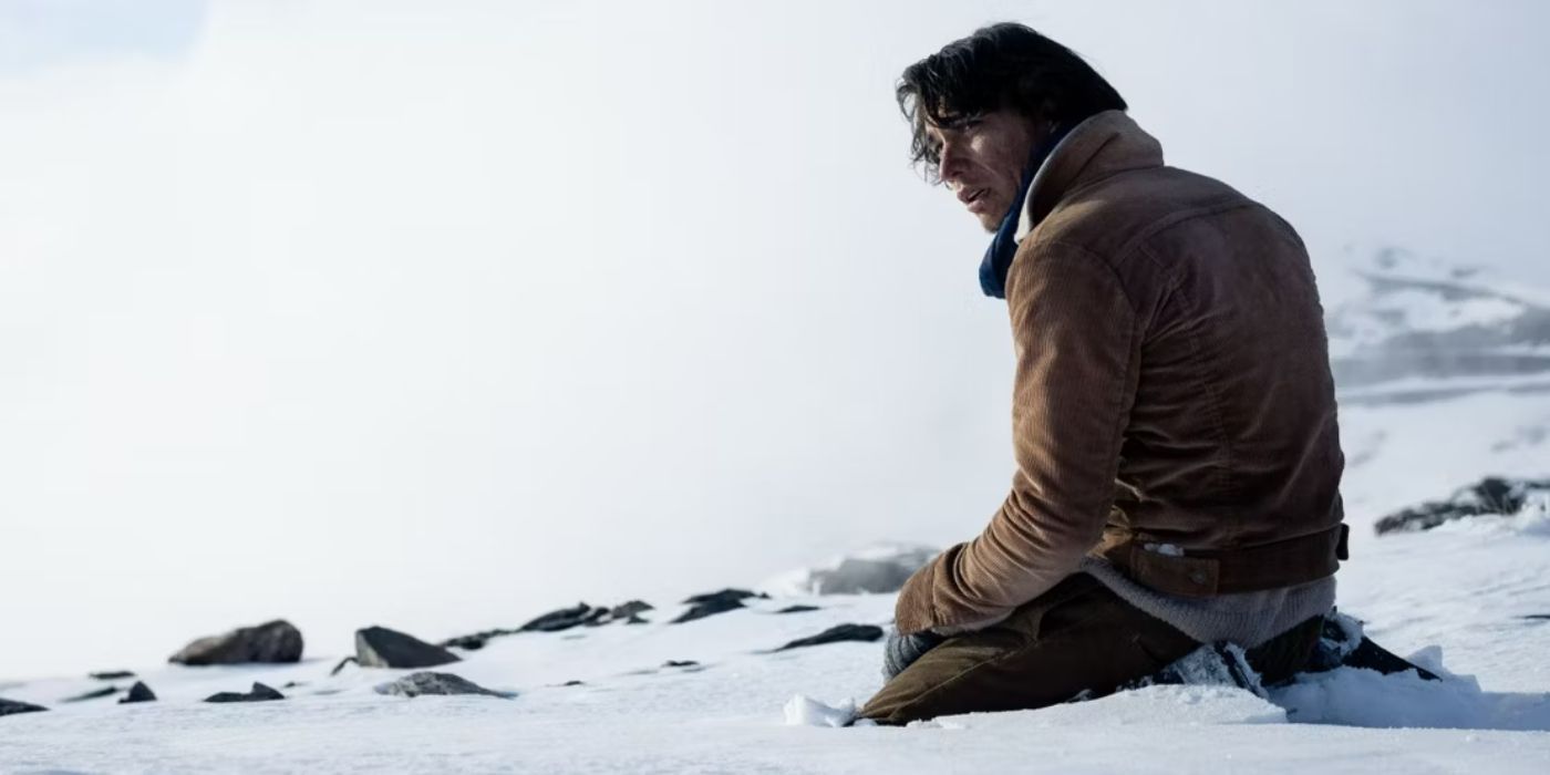 Numa Turcatti, played by Enzo Vogrincic, sits in the snow looking disheveled after his plane crashed