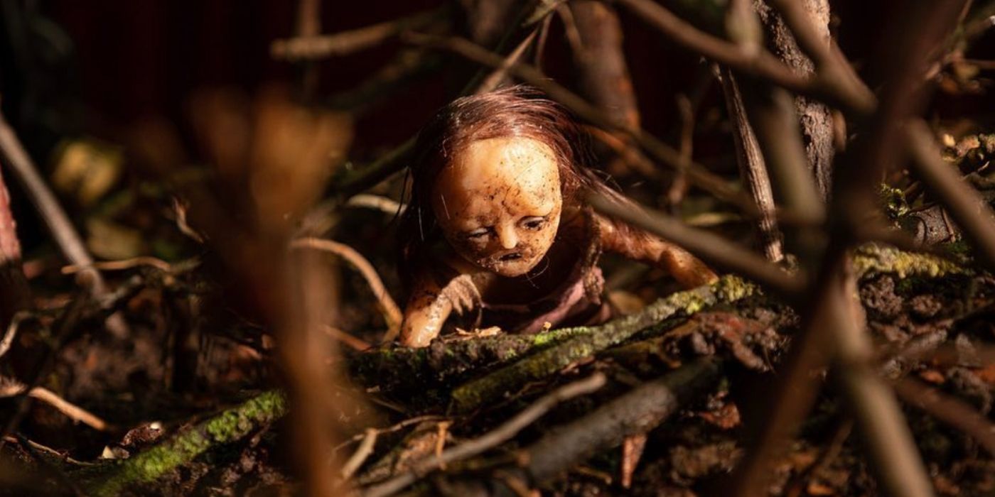 A creepy doll climbing out of a pile of sticks in 2023's Stopmotion.