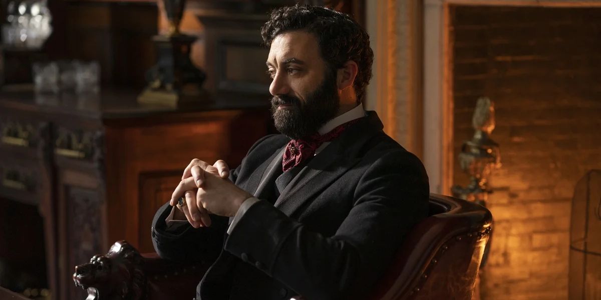 George Russell (Morgan Spector) sitting at his desk