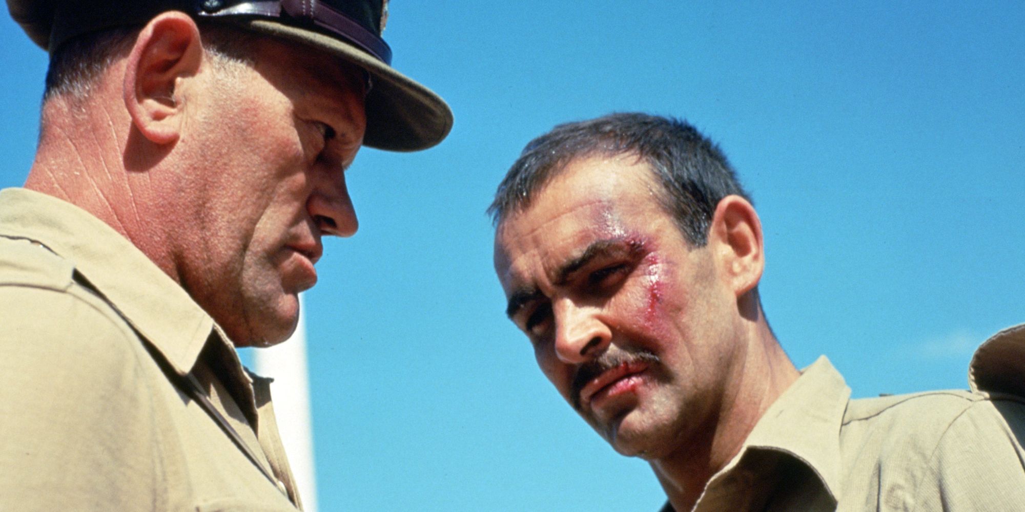 Sean Connery as Joe Roberts looking down while being adressed by another man in The Hill