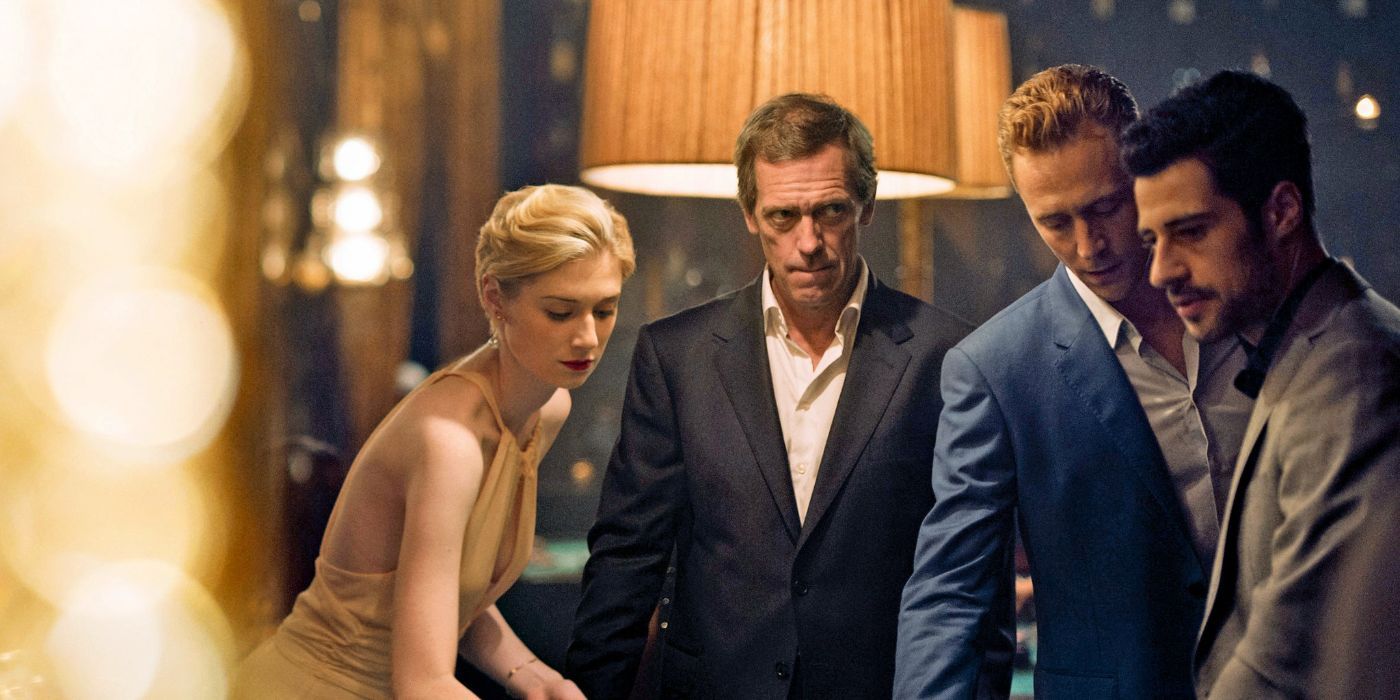 Two men and a woman looking down at something, Hugh Laurie in the background looking creepy in a scene from The Night Manager.