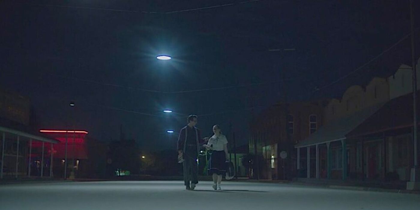 A boy and girl from the 1950s are walking down the street in The Vast of Night