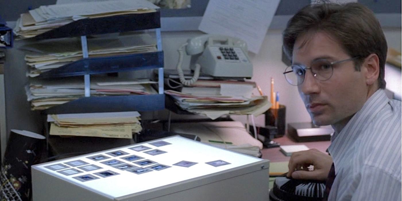 David Duchovny as Special Agent Fox Mulder, FBI, at a cluttered desk in the pilot episode of The X-Files.