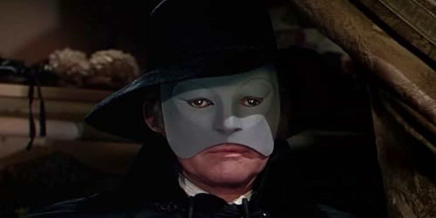 Claude Rains as the Phantom wears a face mask and black hat in The Phantom of the Opera (1943).