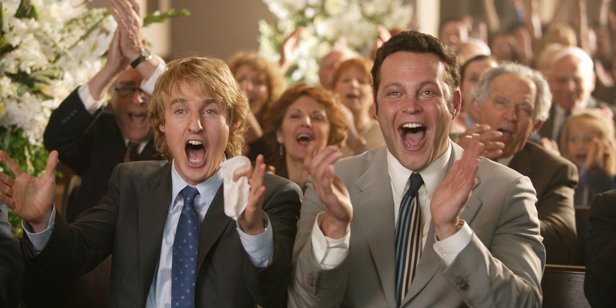 Vince Vaughn and Owen Wilson clapping and smiling in Wedding Crashers. 