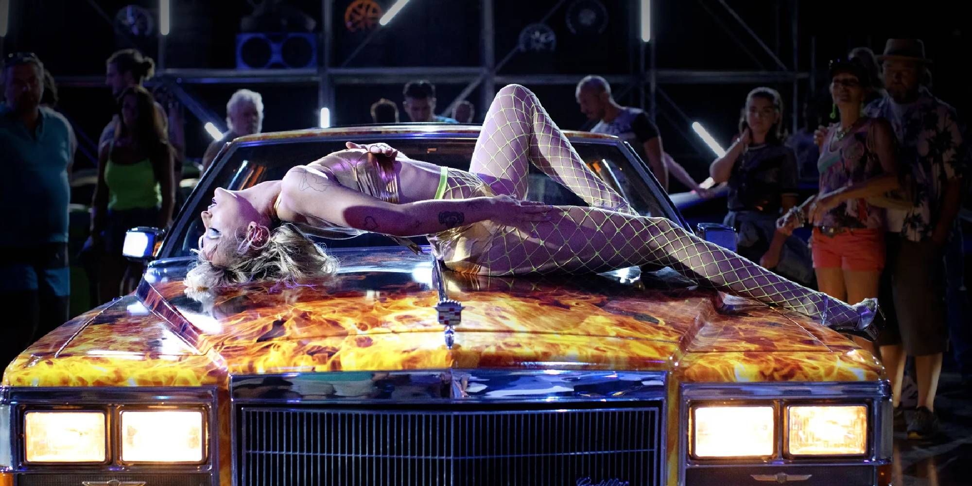 Agathe Rousselle as Alexia lying on top of a car in Titane.