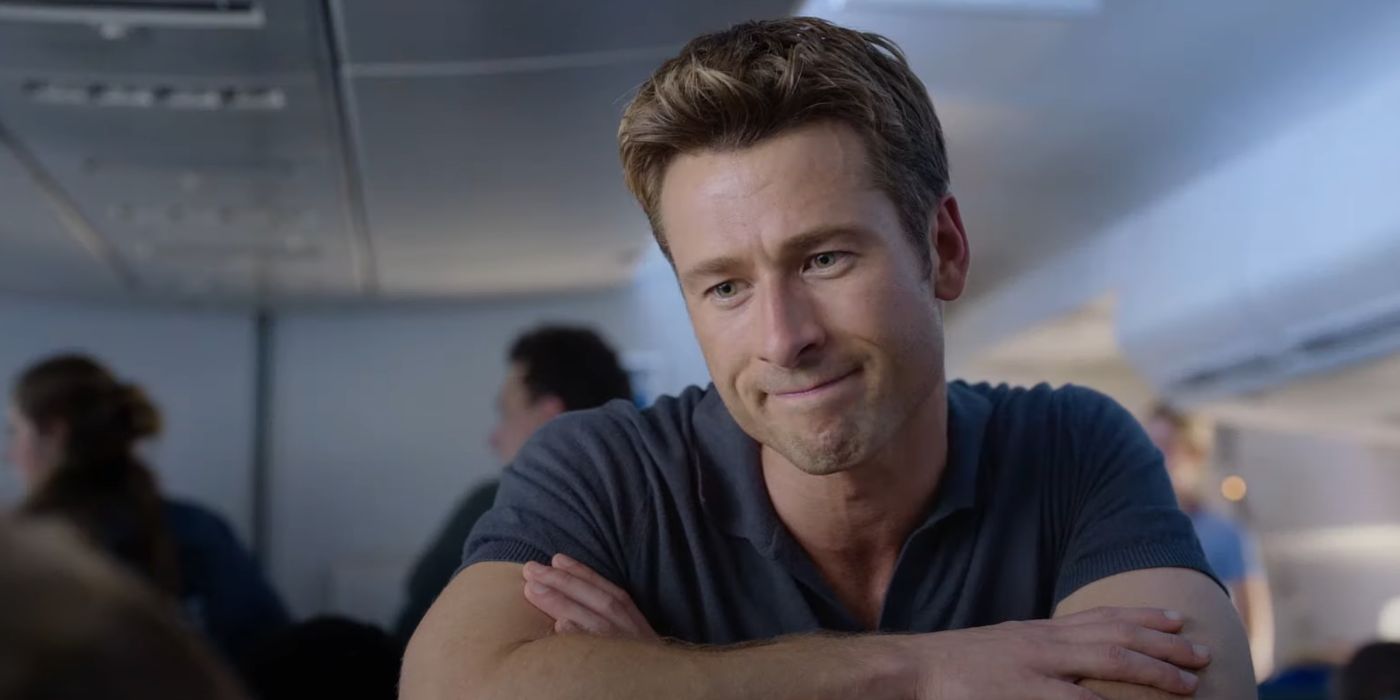 Glen Powell as Ben on an airplane, smirking at person offscreen, in Anyone But You