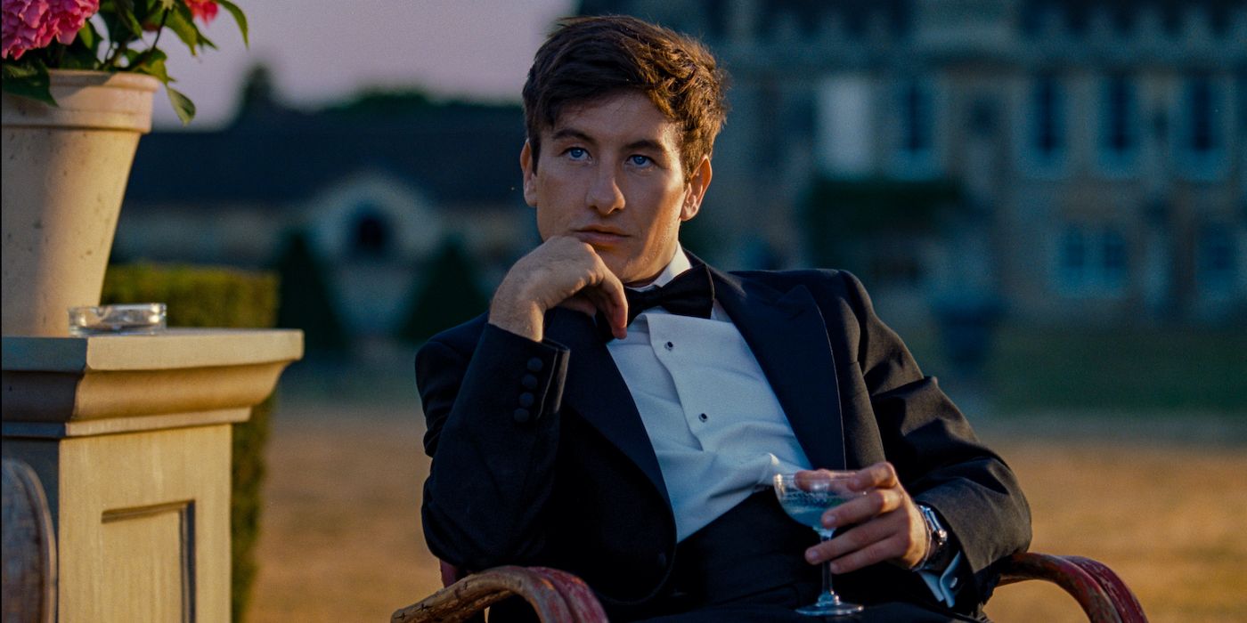 Barry Keoghan as Oliver Quick sitting on a chair with a drink in his hand in Saltburn