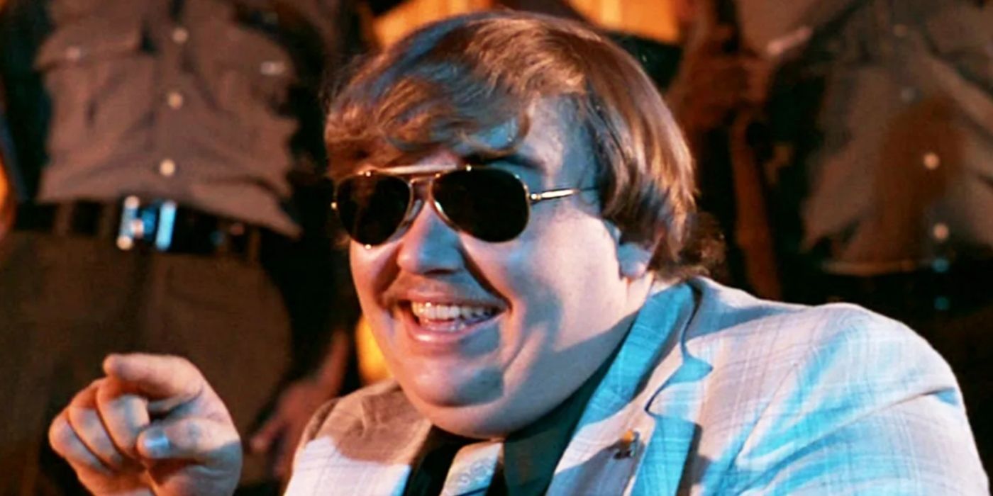 John Candy in Blues Brothers pointing to something off-camera.