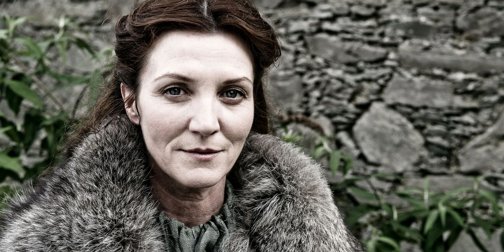 Michelle Fairley as Catelyn Stark smiling softly for the camera in Game of Thrones