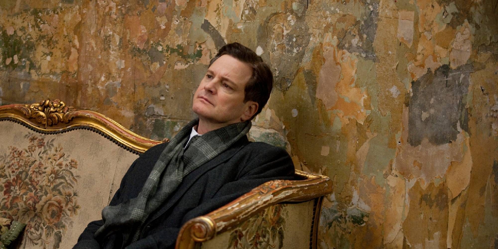 Colin Firth sitting down on a sofa in The King's Speech.