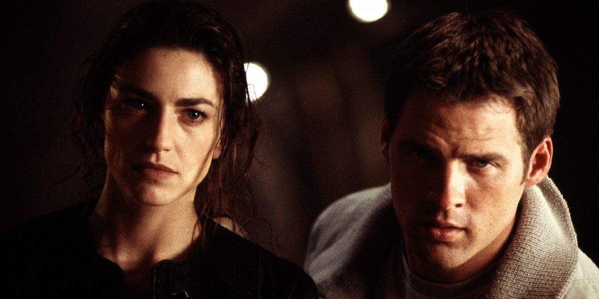 Claudia Black as Aeryn Sun and Ben Browder as John Crichton standing closely together and staring offscreen in the Sci-Fi Channel series Farscape