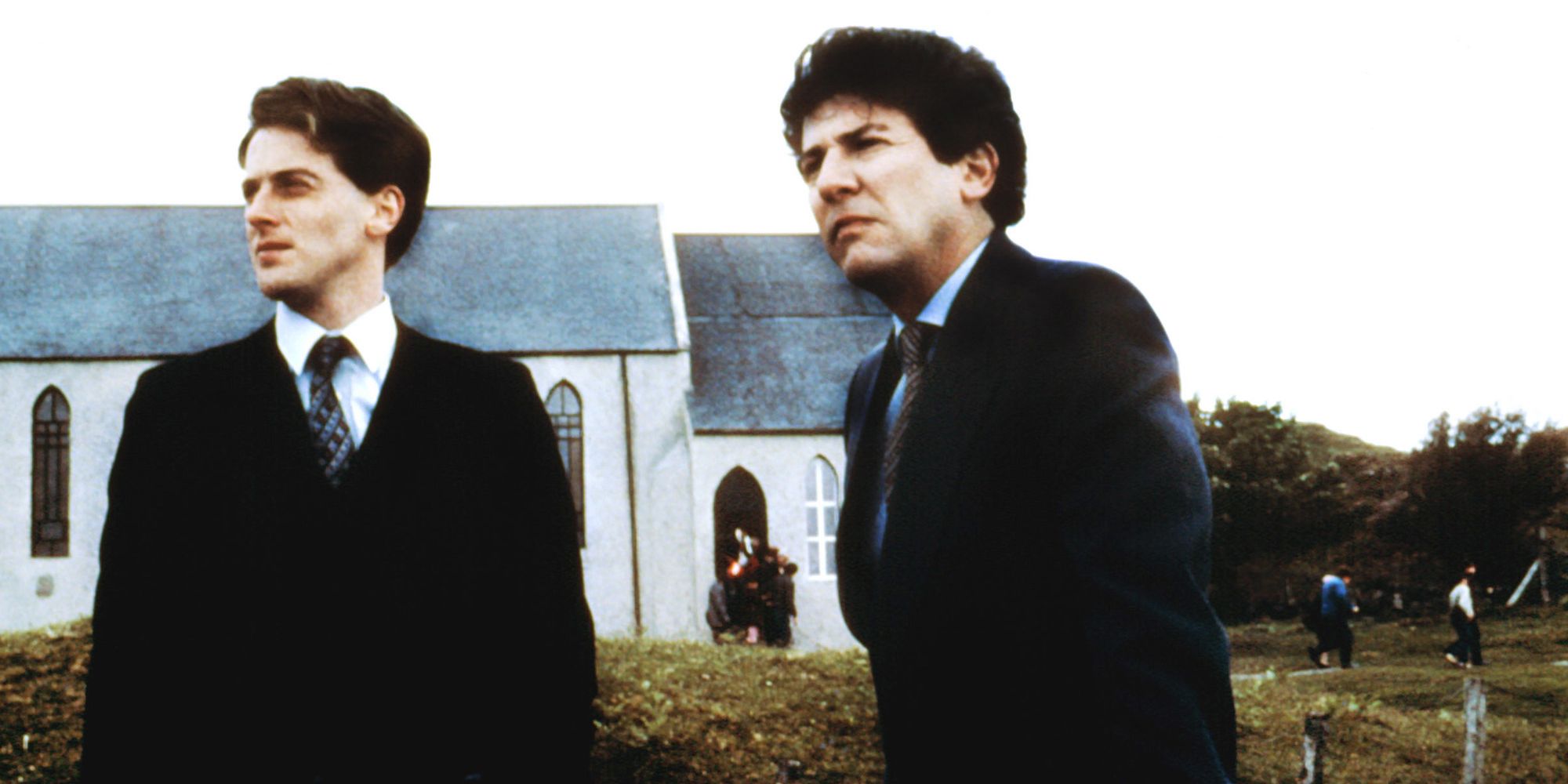 Two men in suits standing in front of a church in Local Hero.