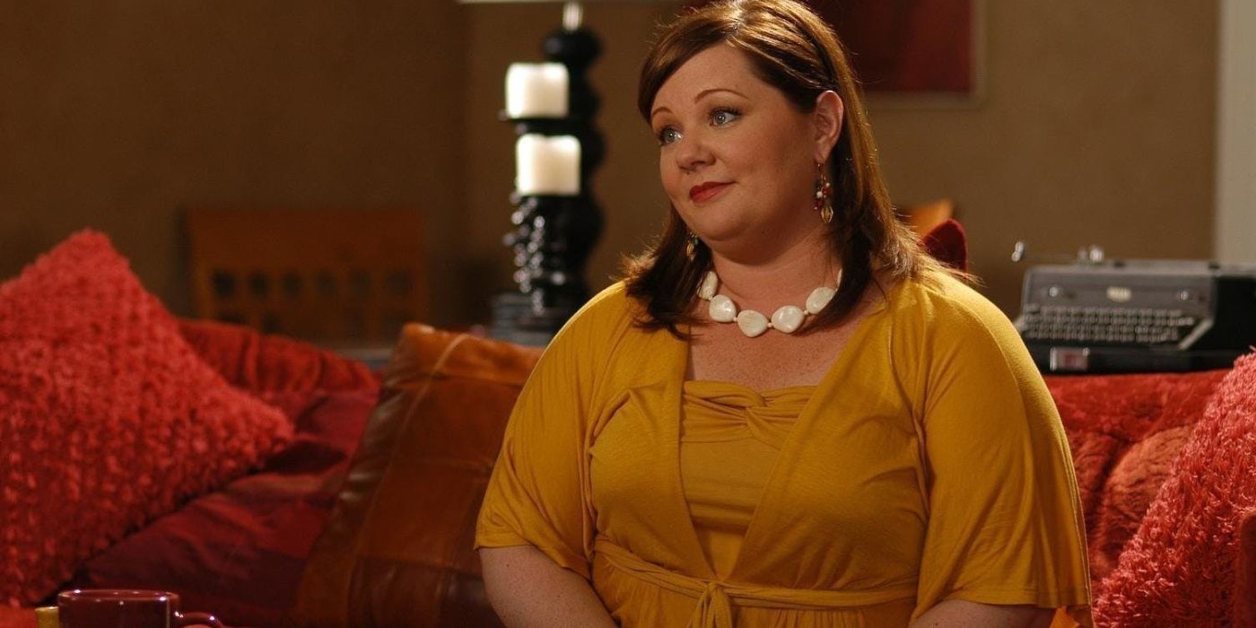 Melissa McCarthy as Margaret sitting on a couch in The Nines