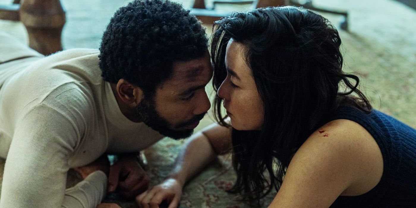 Donald Glover and May Erskine laying on the ground about to kiss in the Mr. and Mrs. Smith TV series