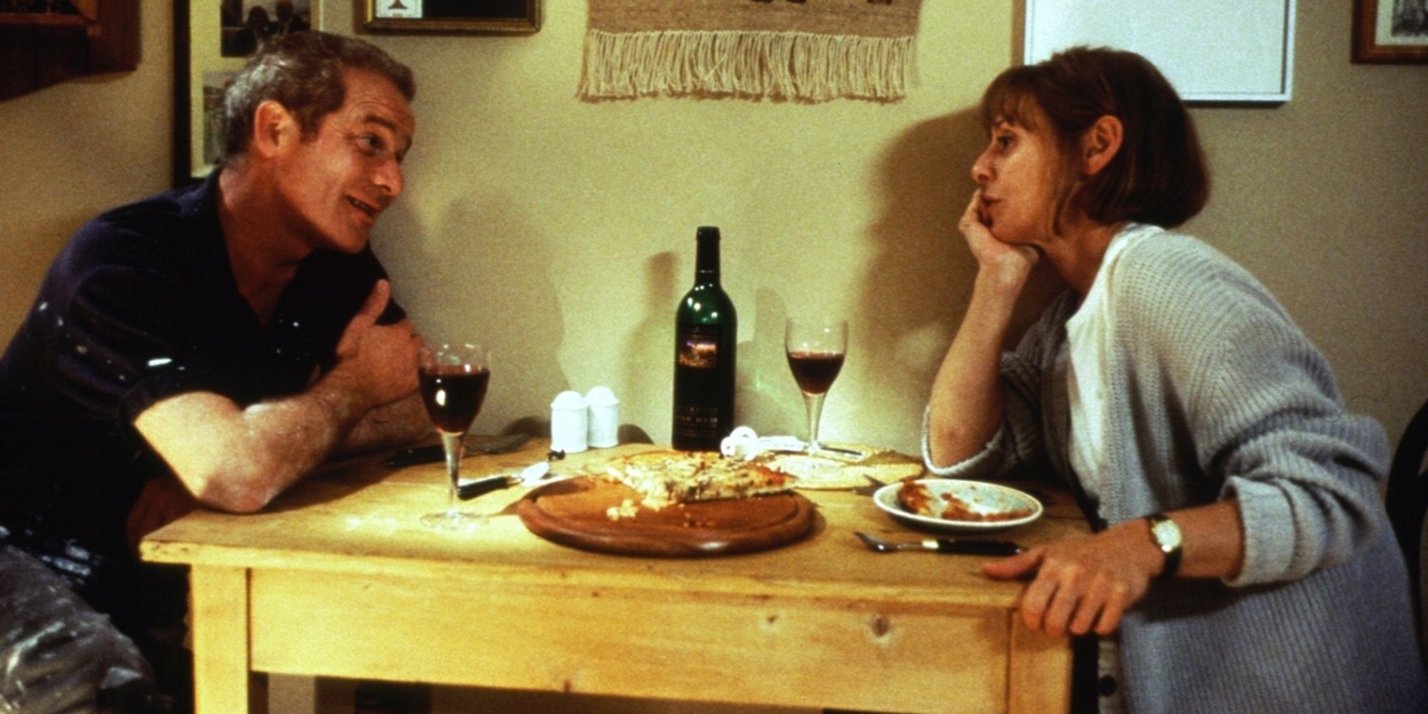 Peter Mullan como Joe Kavanaugh sentado em uma mesa de jantar com Louise Goodall como Sarah Downie em My Name is Joe