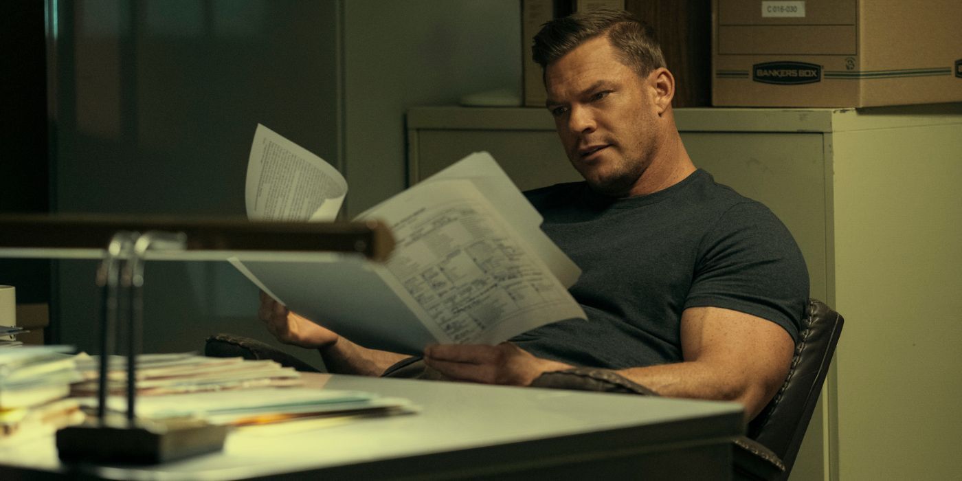 Alan Ritchson as Jack Reacher, reading a file in an office in Reacher Season 2