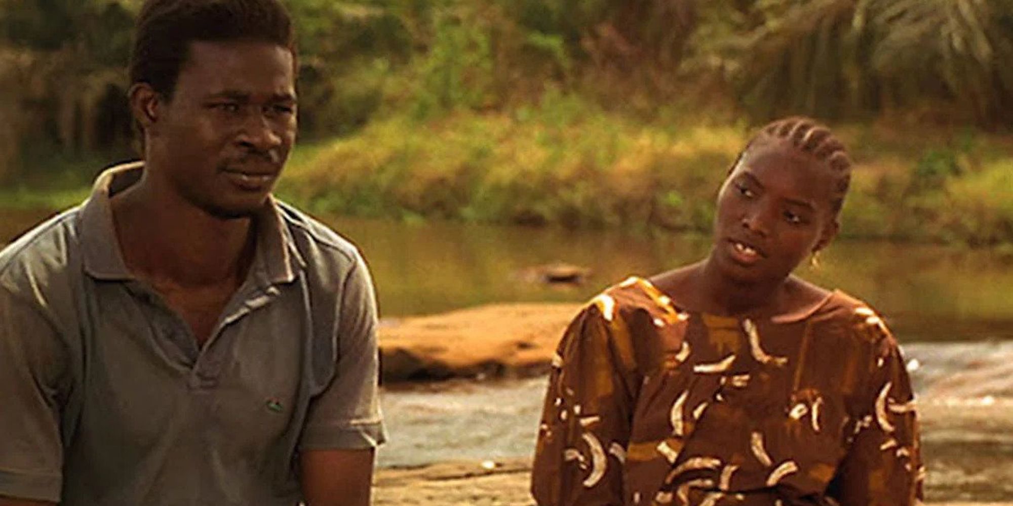 A woman looking at a pensive-looking man in the film Samba Traoré