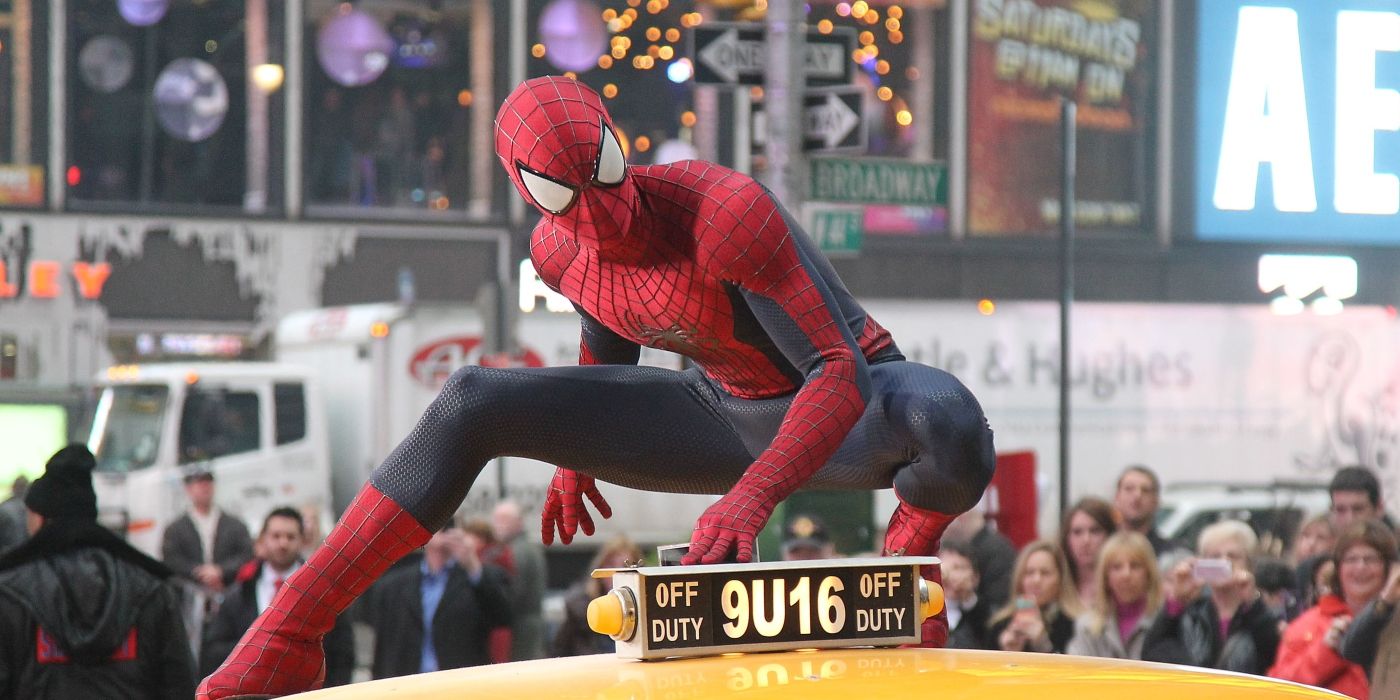 Spider-Man atop a taxi with a crowd looking from behind in The Amazing Spider-Man 2