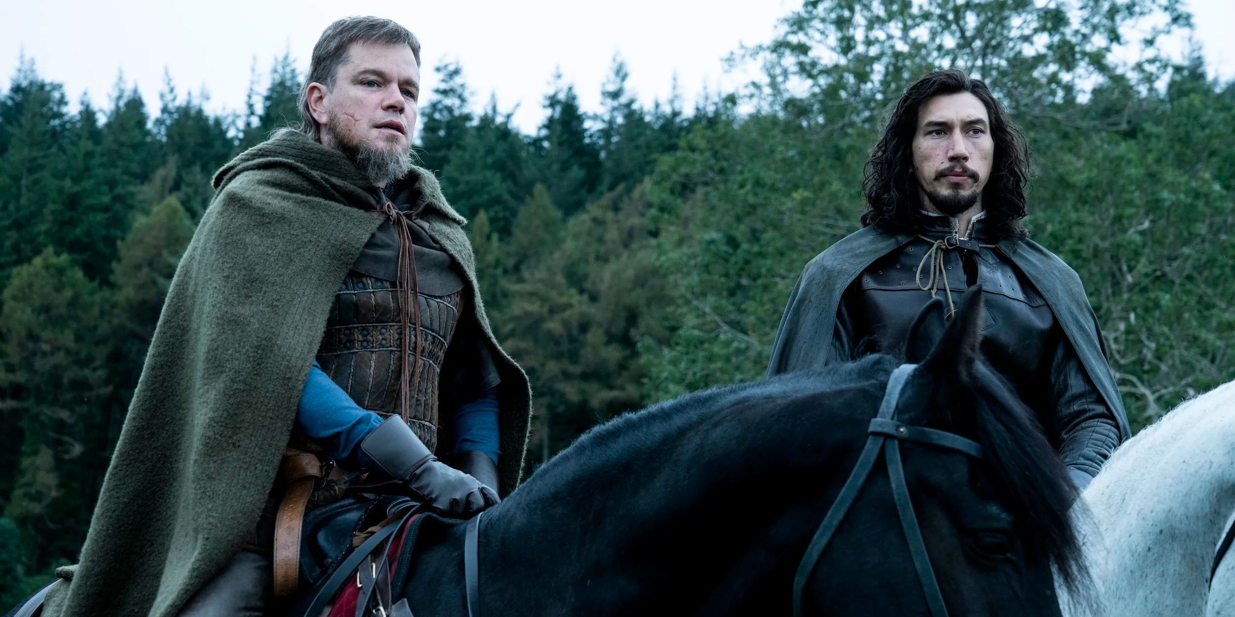 Matt Damon and Adam Driver as Jean de Carrouges and Jacques Le Gris on horseback looking to the distance in &lsquo;The Last Duel&rsquo; (2021)