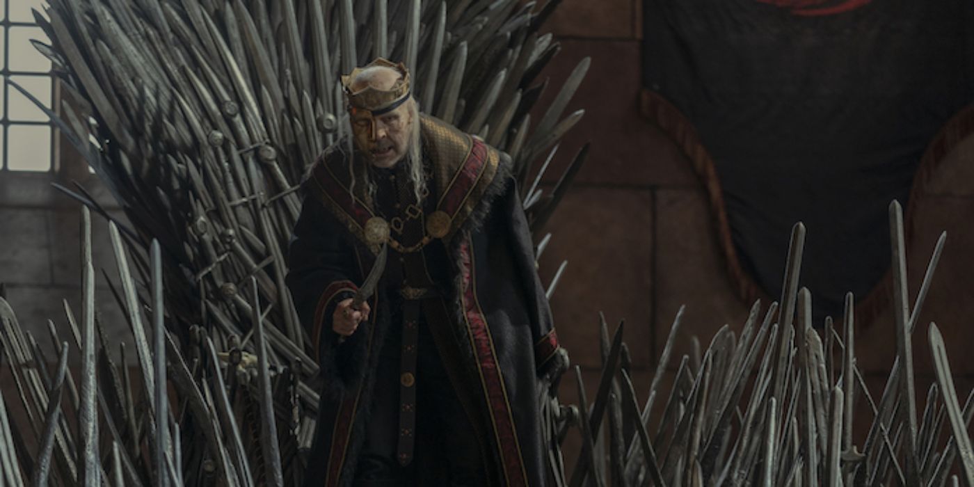 Rhys Ifans as Otto Hightower standing in front of the Iron Throne