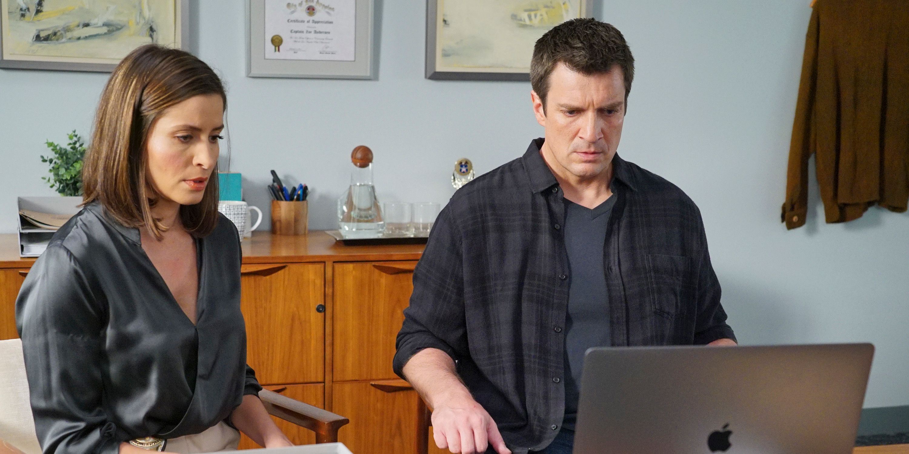 Nathan Fillion & Mercedes Mason as John Nolan & Zoe Andersen, look solemnly at a laptop screen in The Rookie