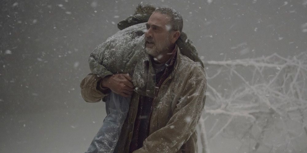 Negan (Jeffrey Dean Morgan) carries Judith to safety through a blizzard in 'The Walking Dead'