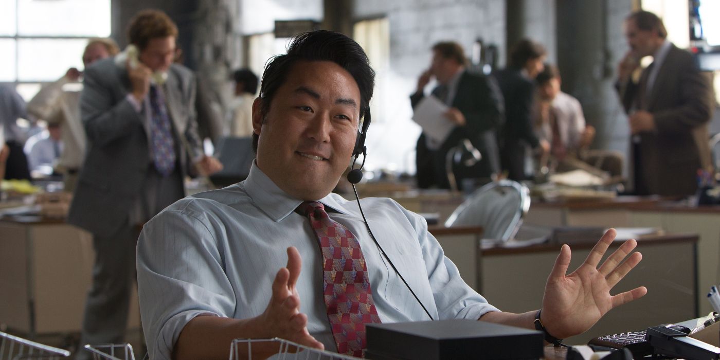 Kenneth Choi sitting at a desk with a headset on in The Wolf of Wall Street