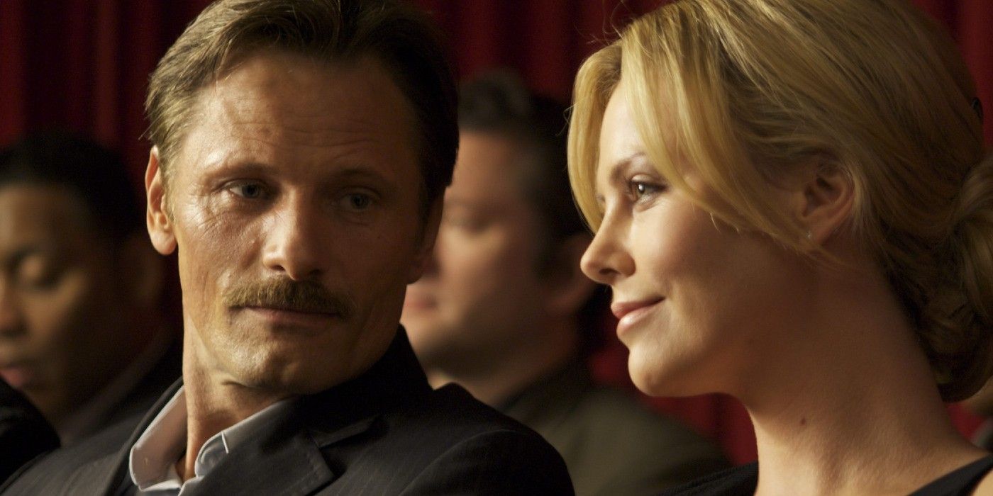 Man (Viggo Mortensen) looks at Woman (Charlize Theron) in a pew during church service.