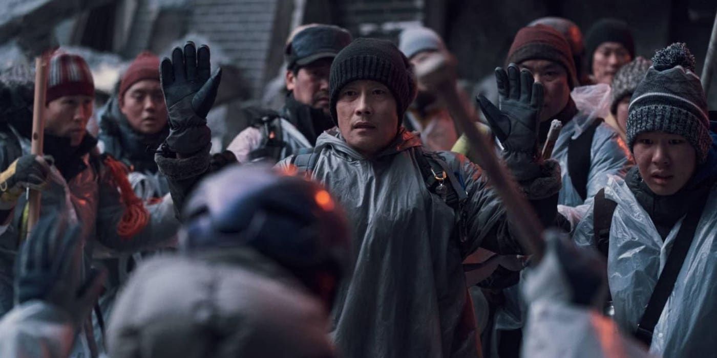 Lee Byung-hun as Yeong-tak raising his hands in Concrete Utopia.