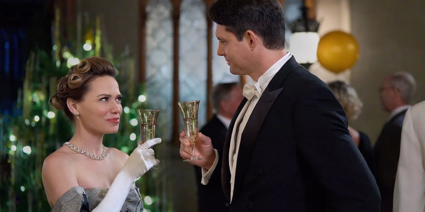 Bethany Joy Lutz as Lucy in a glamorous ballgown toasting a man in a tuxedo in Hallmark&rsquo;s A Biltmore Christmas