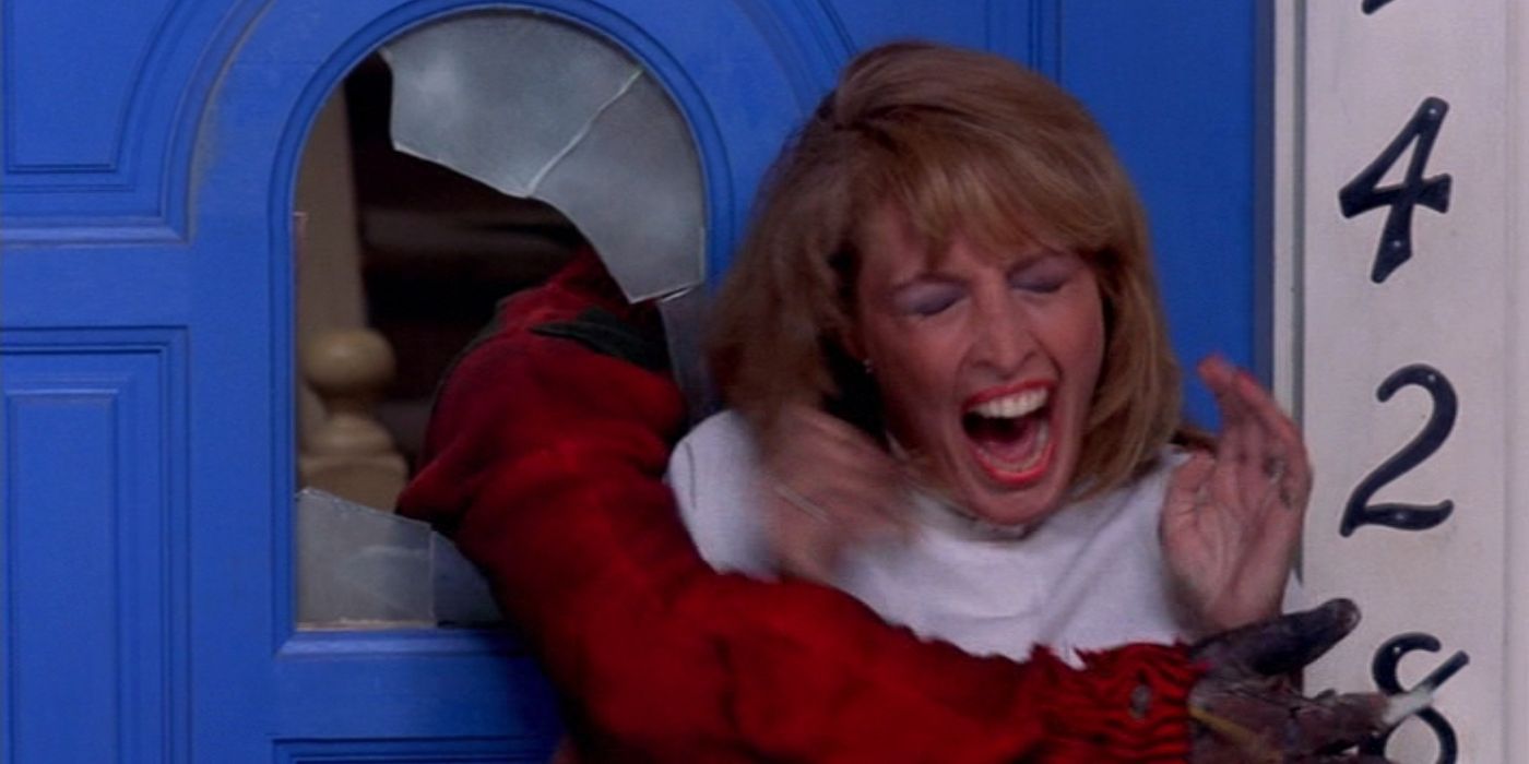 Nancy&rsquo;s mother, played by Ronee Blakley, screams as Freddy Krueger&rsquo;s arm grabs her through a broken door window in A Nightmare on Elm Street
