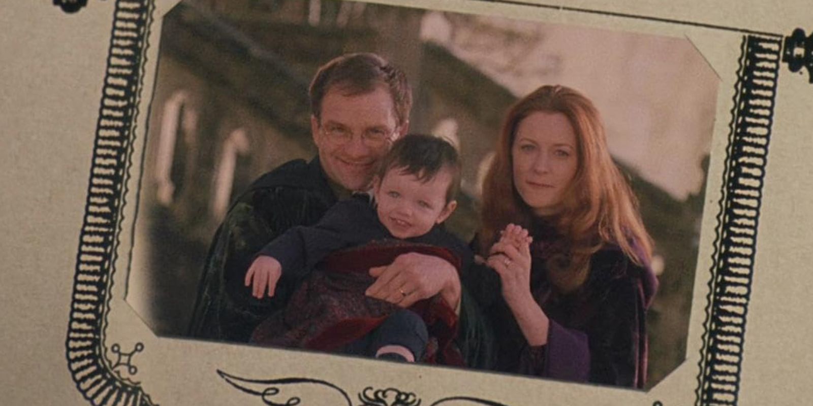 James (Adrian Rawlins) holds baby Harry (Saunders Triplets) beside Lily (Geraldine Somerville) in a photo album in 'Harry Potter and the Sorcerer's Stone'