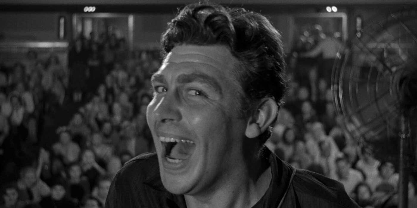 Andy Griffith smiling, facing away from a large crowd