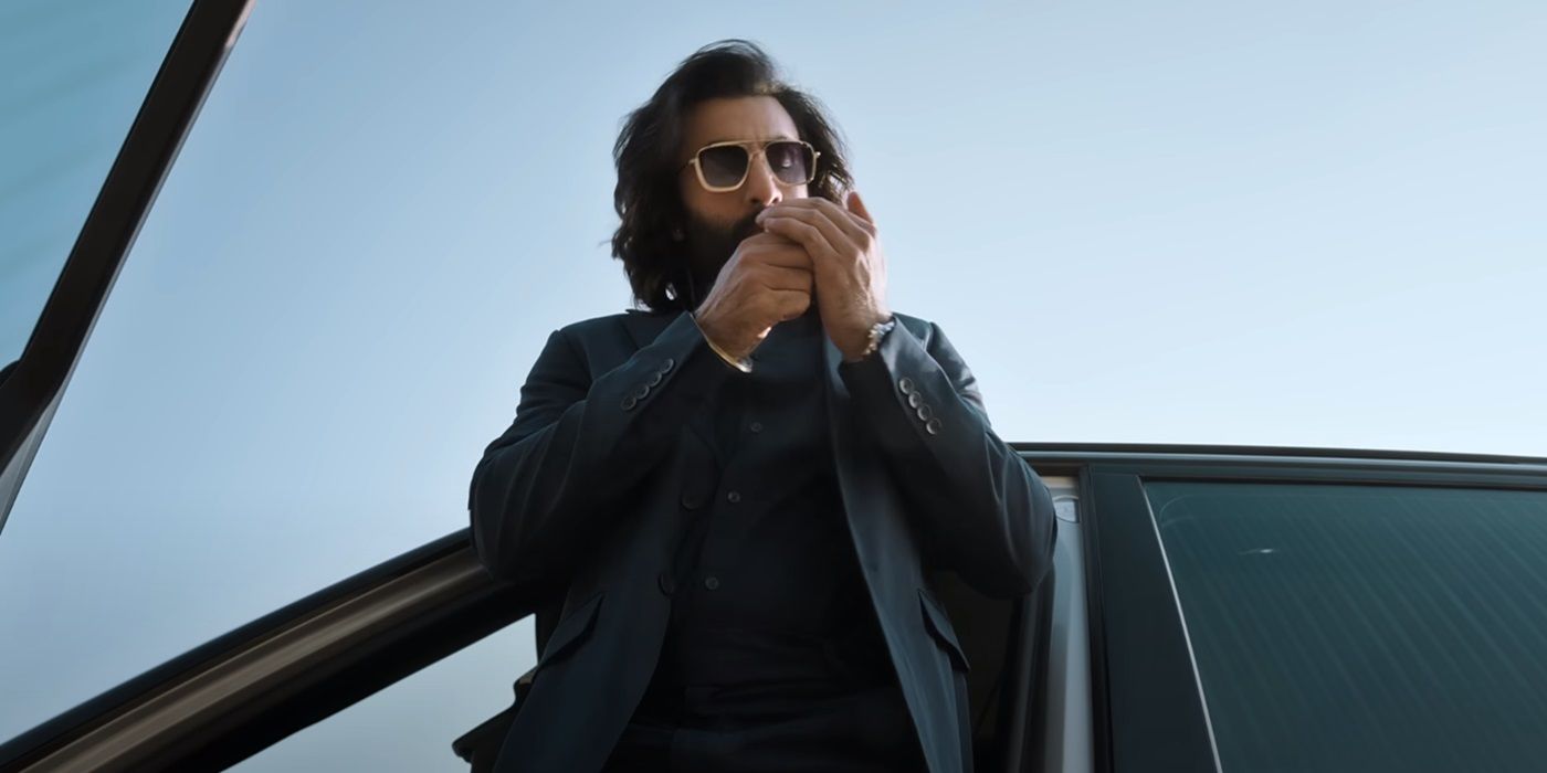 Ranbir Kapoor as Vijay Singh lighting a cigarette while standing outside a car in Animal (2023)