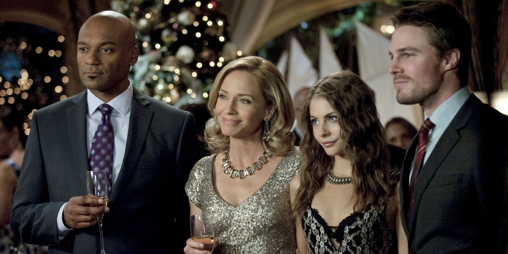 Oliver, Thea, Moira, and Walter at the Christmas party in Arrow&rsquo;s &ldquo;Year&rsquo;s End&rdquo;