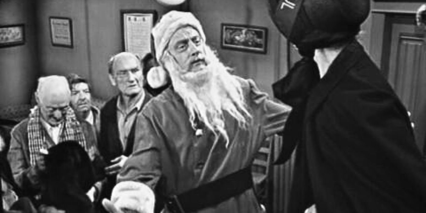 Art Carney dressed as Santa Claus standing with arms open in front of a woman in The Twilight Zone