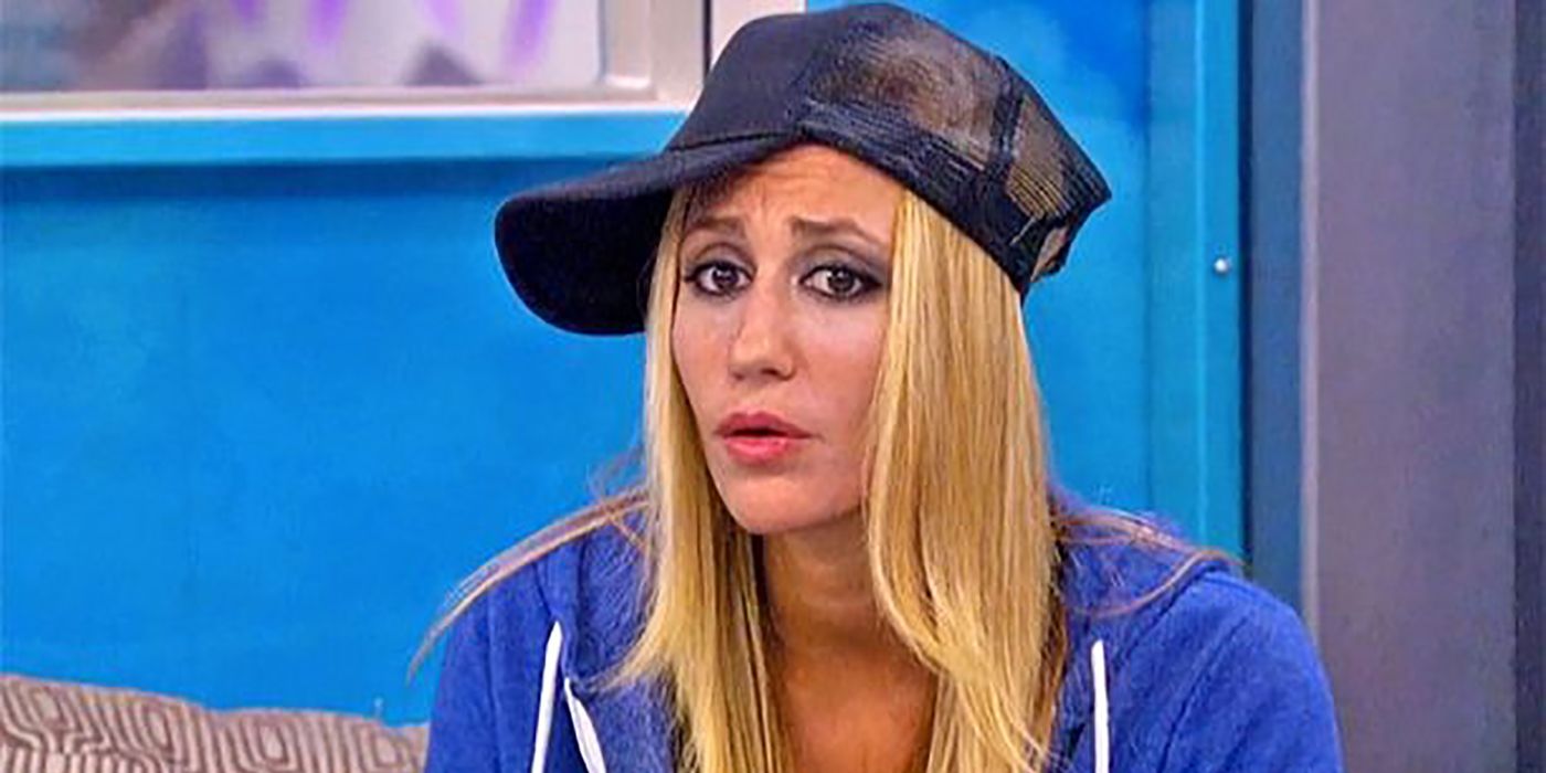 Vanessa from Big Brother sitting down with a baseball cap sideways.