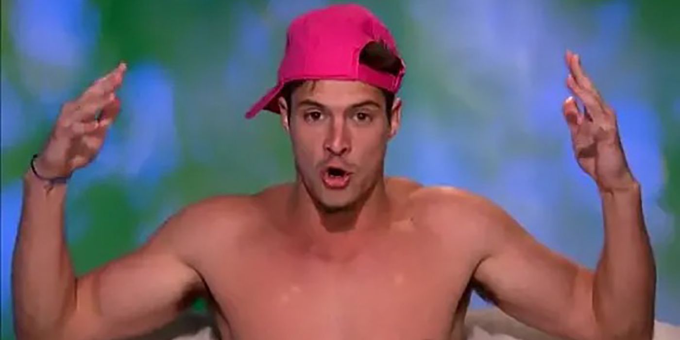 Zach Rance in the Diary Room on Big Brother wearing a pink hat with his hands up talking.