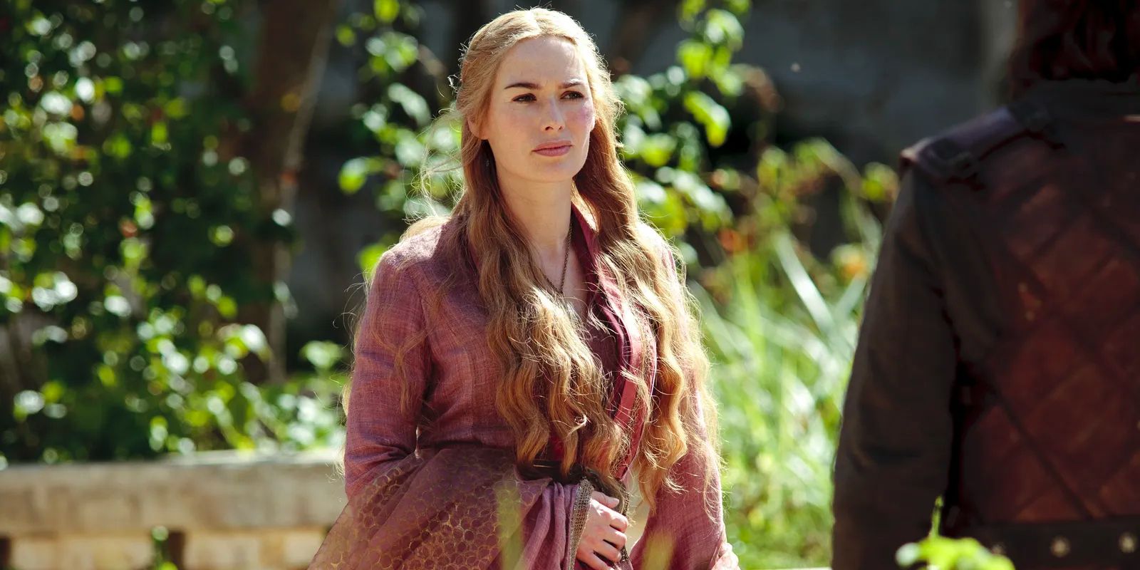 Cersei Lanniser (Lena Headey) stands in a courtyard talking to one of her men.