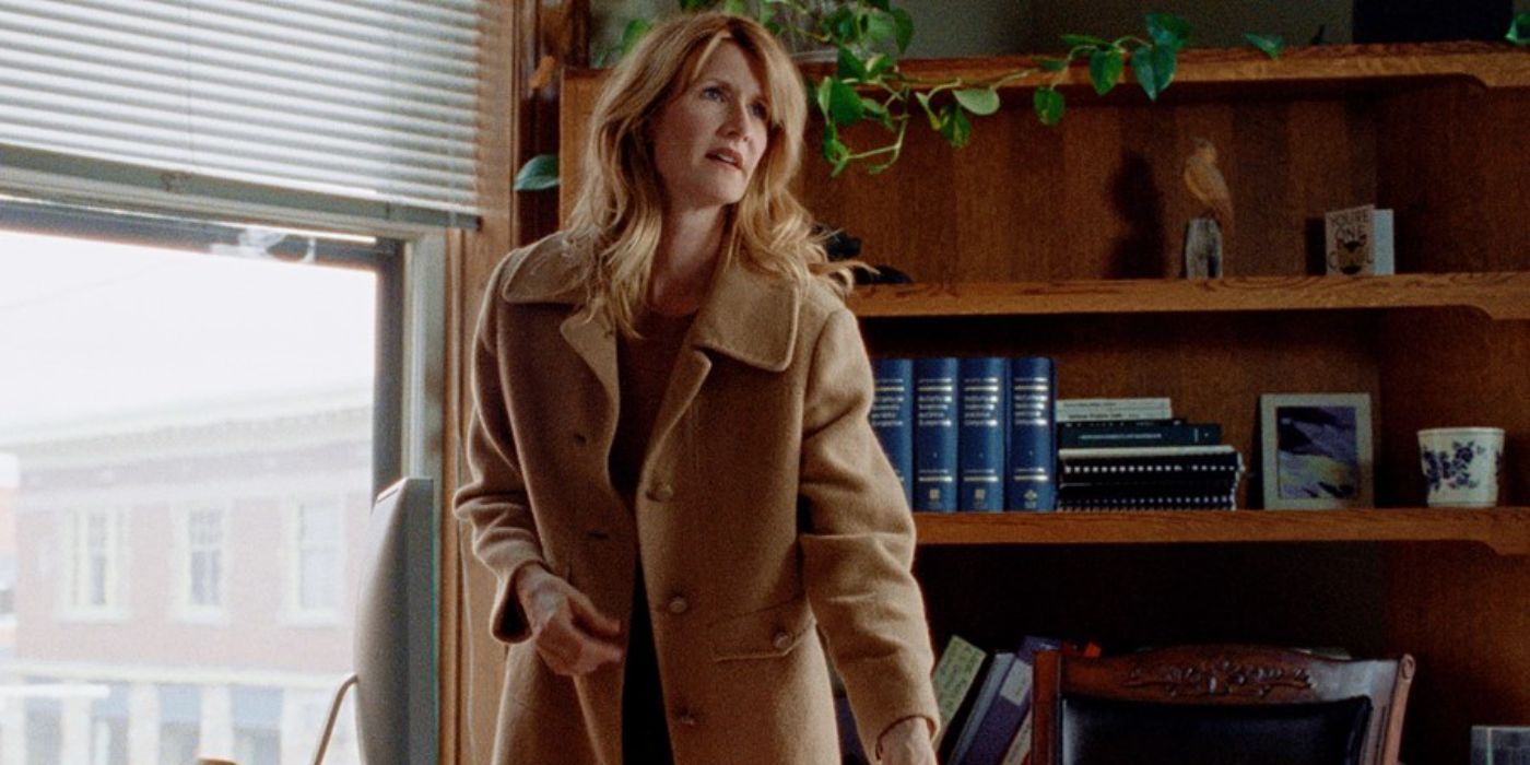 Laura Dern wears a coat and stands in an office in Certain Women.