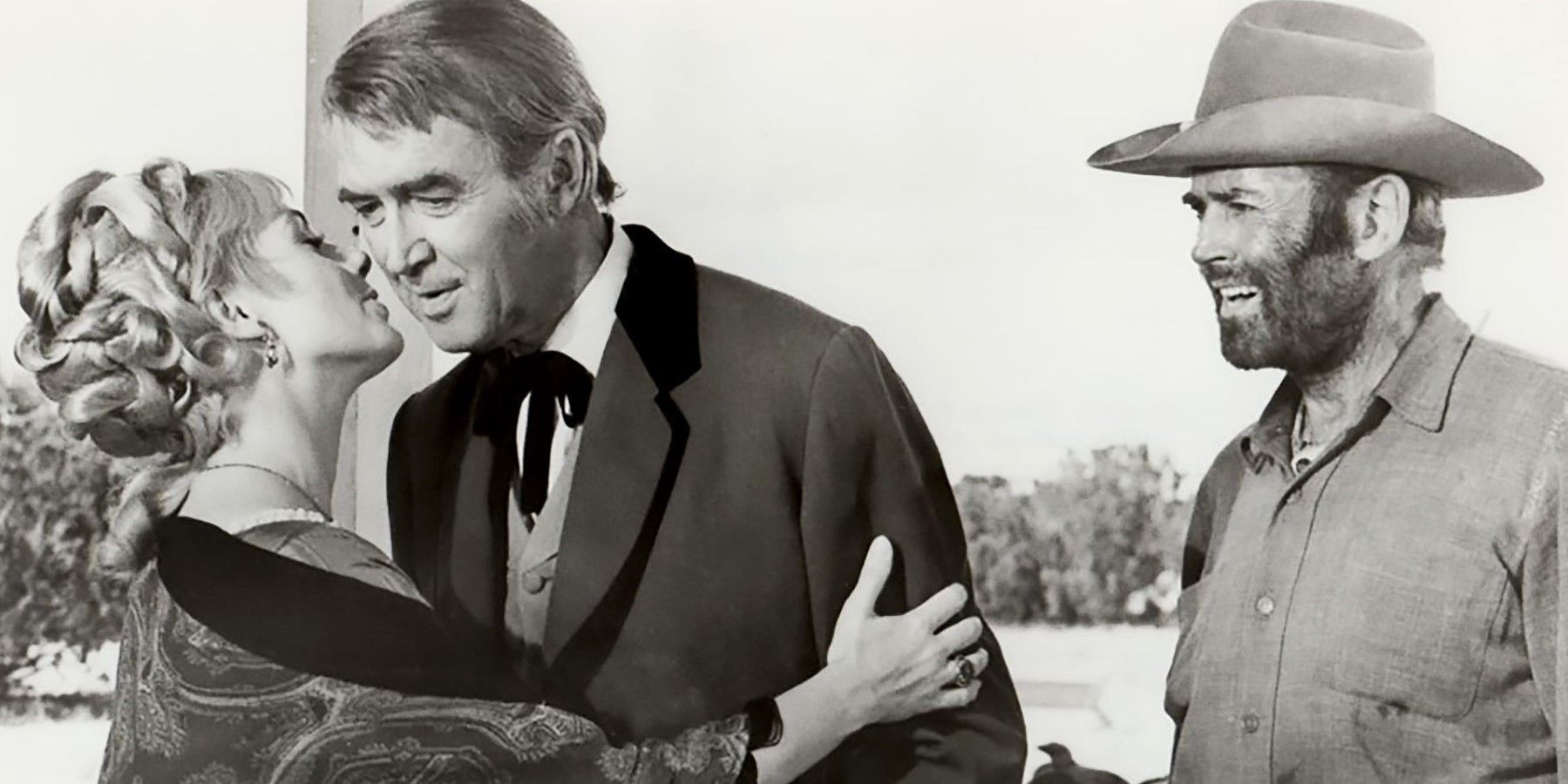 James Stewart as John O'Hanlan, Henry Fonda as Harley Sullivan, and Shirley Jones as Jenny leaning in to kiss John on the cheek in 'The Cheyenne Social Club'