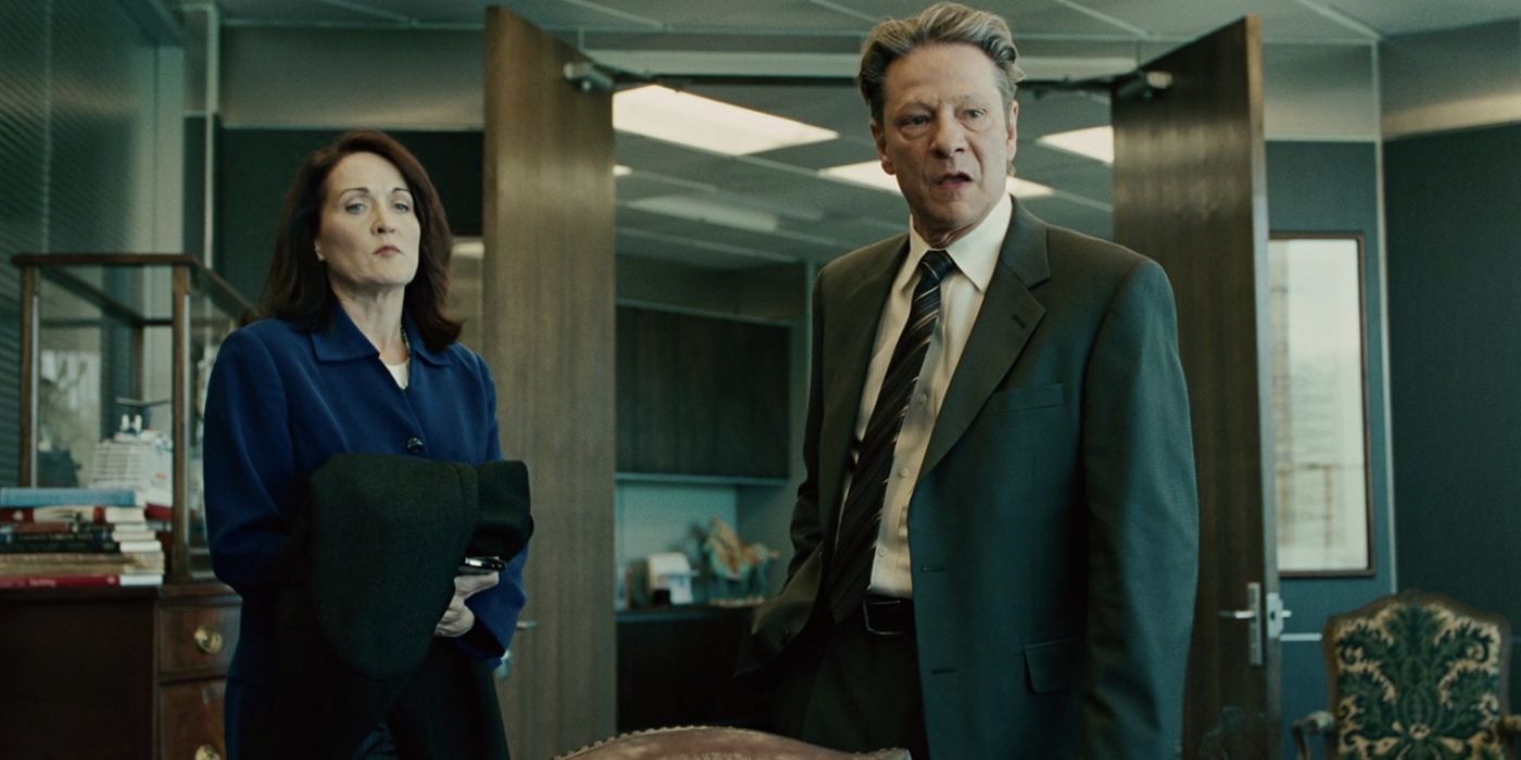 Chris Cooper as Phil Woodard looking at someone off-camera while a woman stands besides him in The Company Men