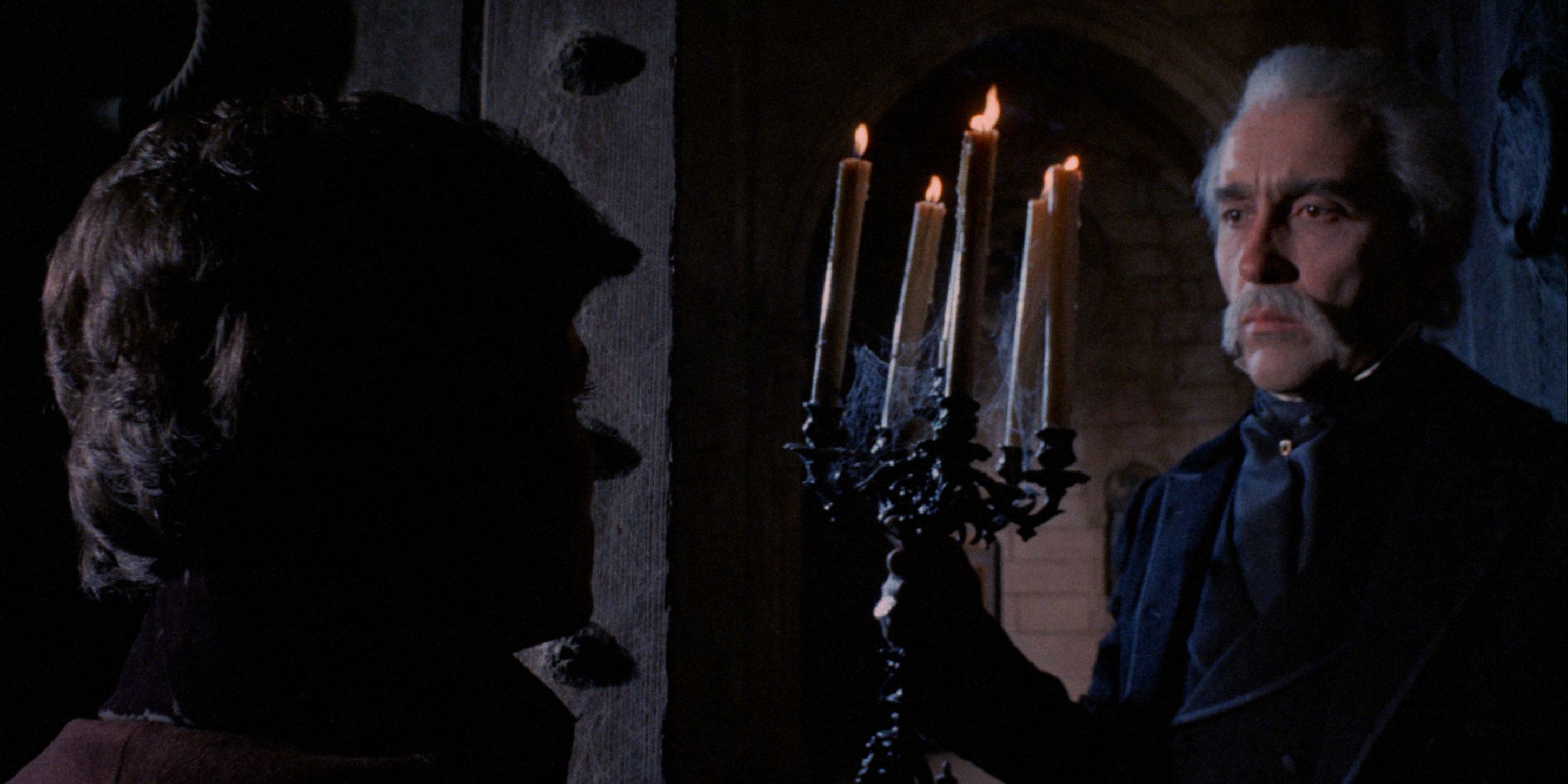 Christopher Lee as Dracula holding a candlelabra in the open doorway of his castle in Jesús Franco&rsquo;s 1970 Count Dracula