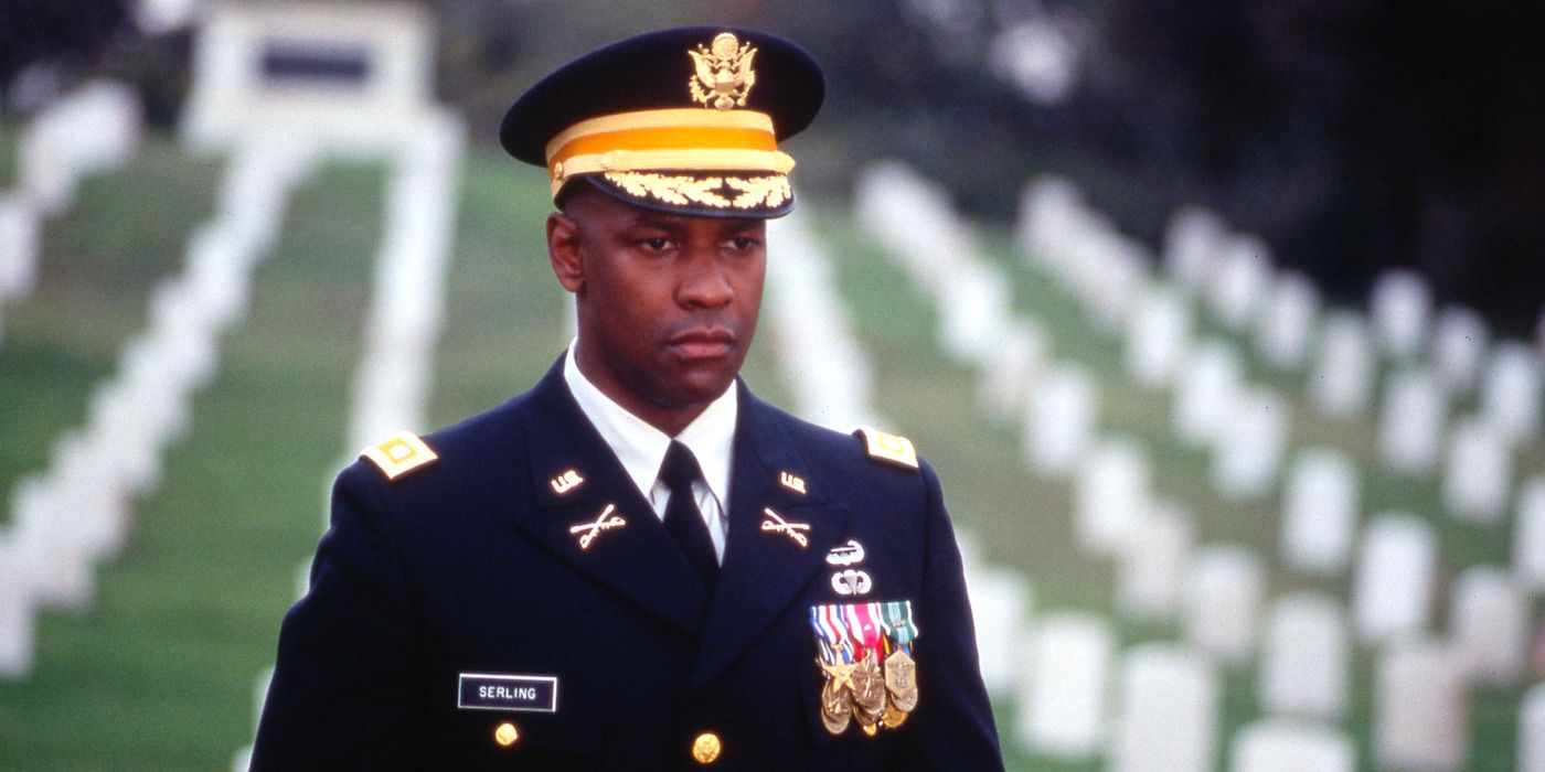A decorated solider wears a blank expression as he stands in a cemetery for soldiers.
