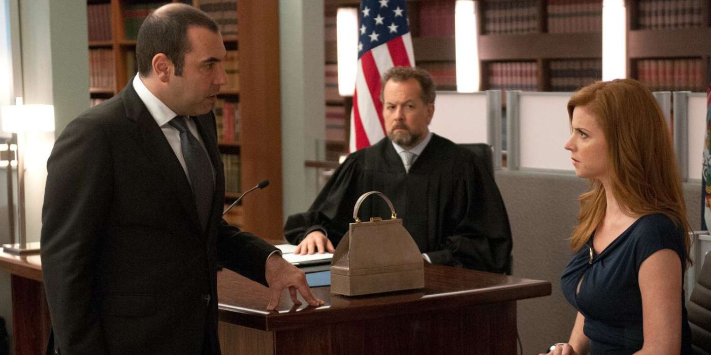 Louis Litt questioning Donna on the witness stand while Daniel Hardman presides during a mock trial