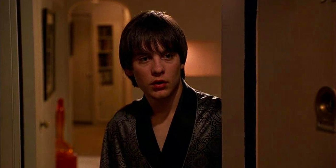 Tobey Maguire as Harvey in a dressing gown opens a door with a dazed look on his face in Deconstructing Harry.