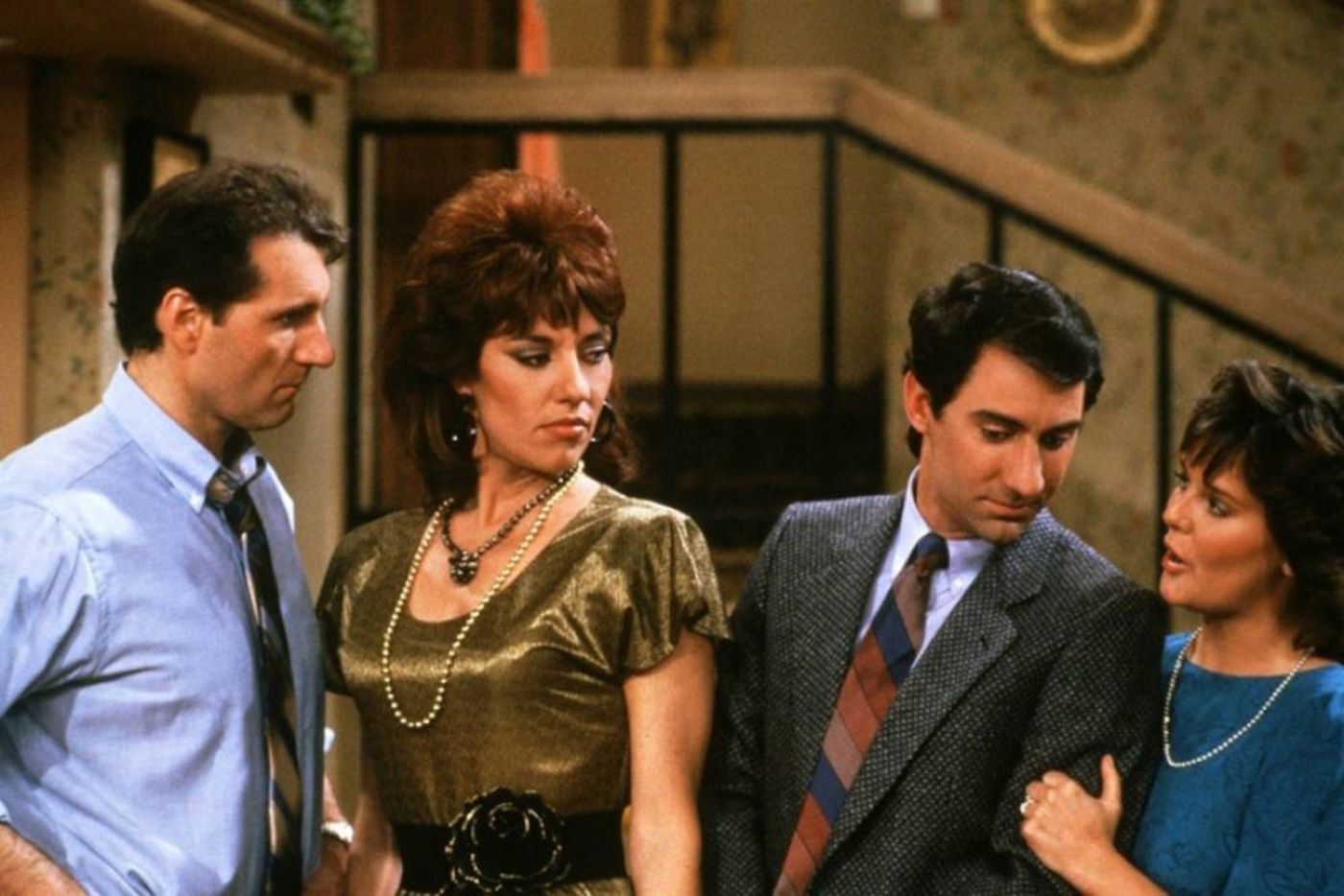 Ed ONeill as Al Bundy, Katey Sagal as Peggy Bundy, David Garrison as Steve Rhoades and Amanda Bearse as Marcy D'Arcy/Rhoades standing alongside each other in the Bundys' house in Married...With Children