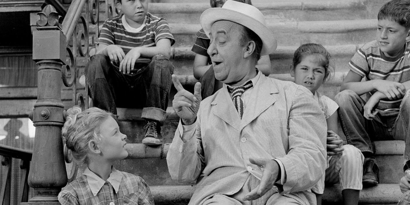 Ed Wynn sitting on a stoop talking to several children sitting around him in The Twilight Zone