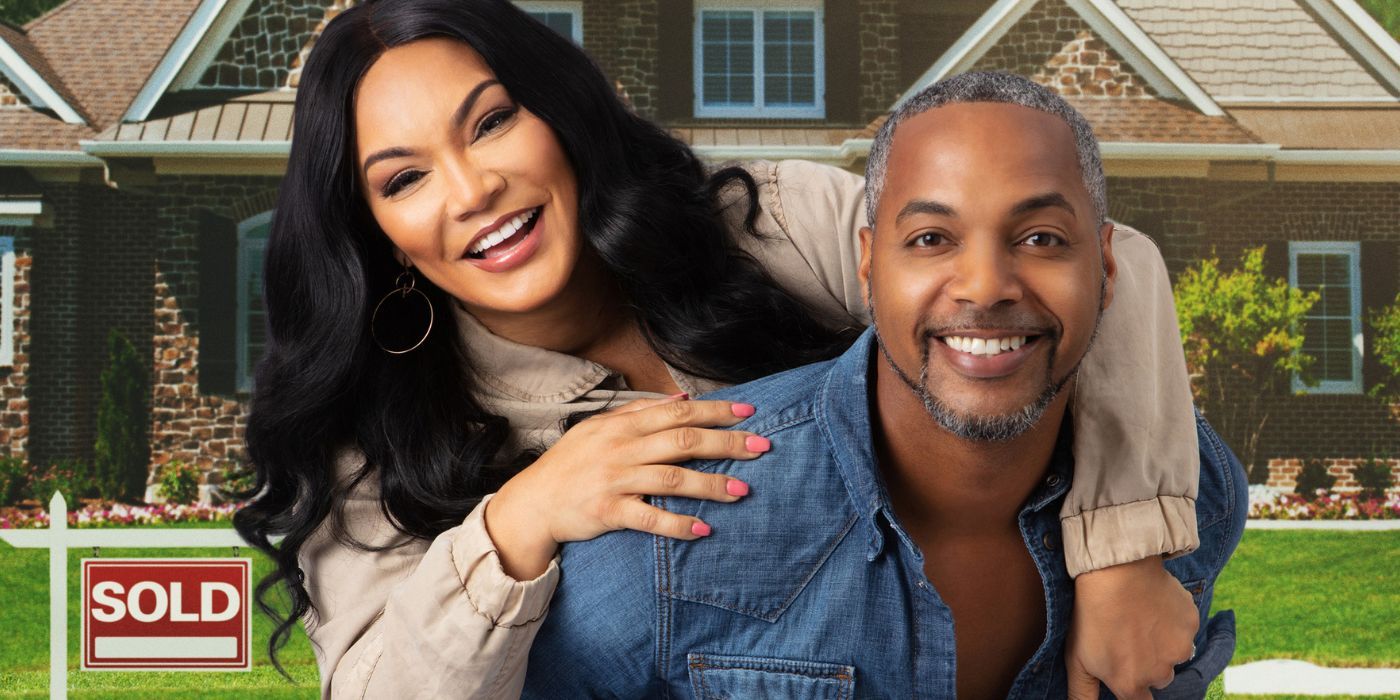 Egypt Sherrod behind Mike Jackson, smiling in front of a "sold" house backdrop in Married to Real Estate.